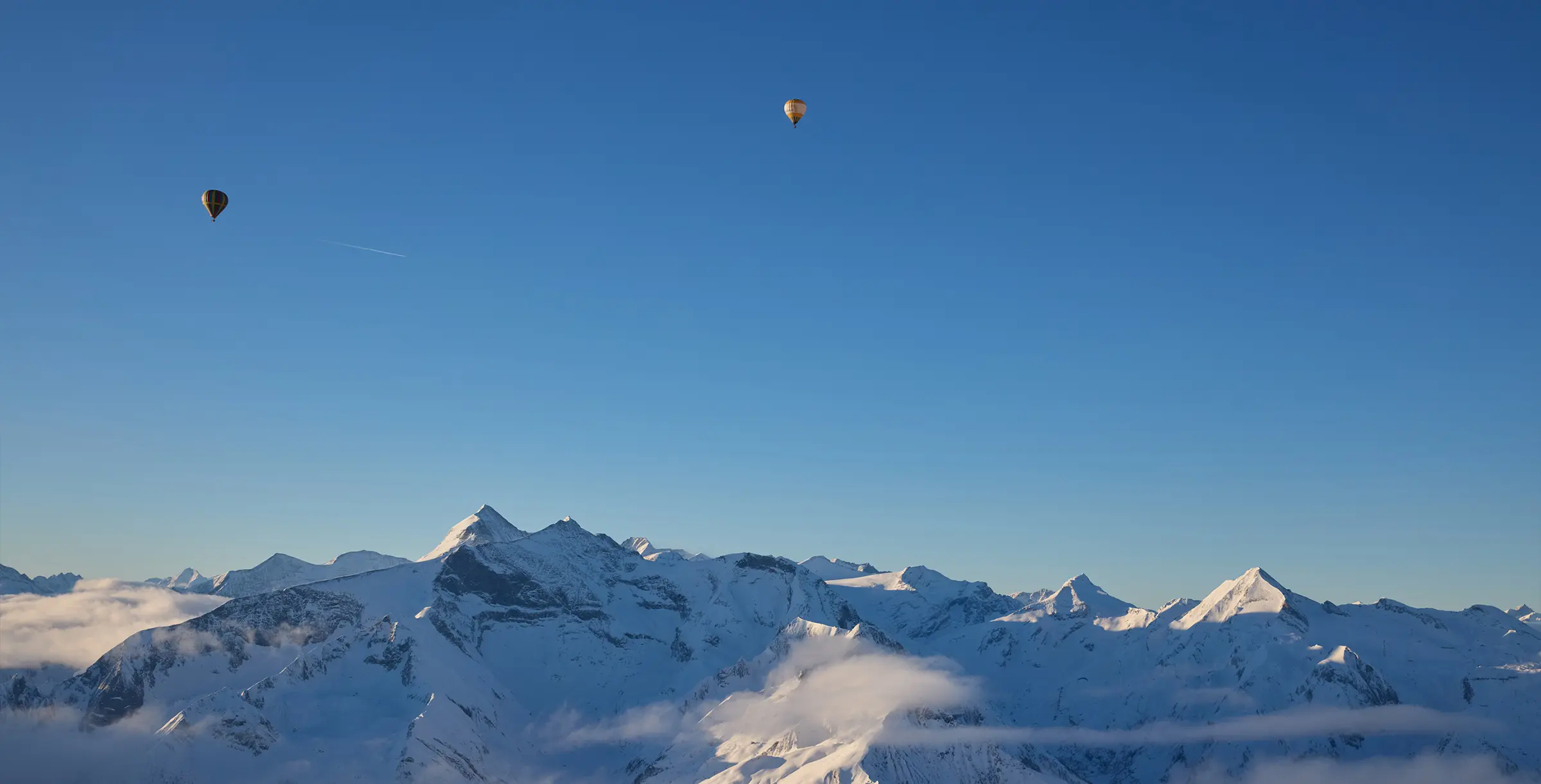 Balloons floating over mountain peaks